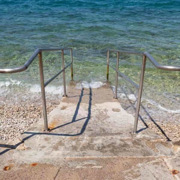 concrete stairs leading into a clear blue sea