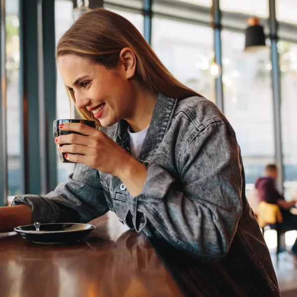 Woman drinking coffee on phone