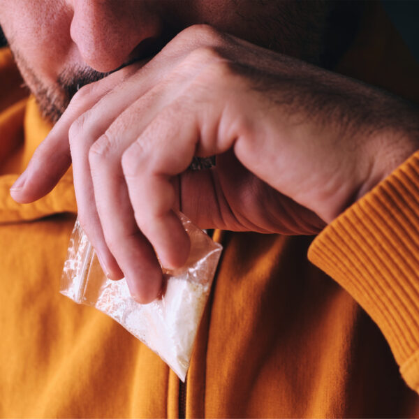 How Does Cocaine Make You Lose Weight? - an image of a man holding a bag of cocaine in his hand.