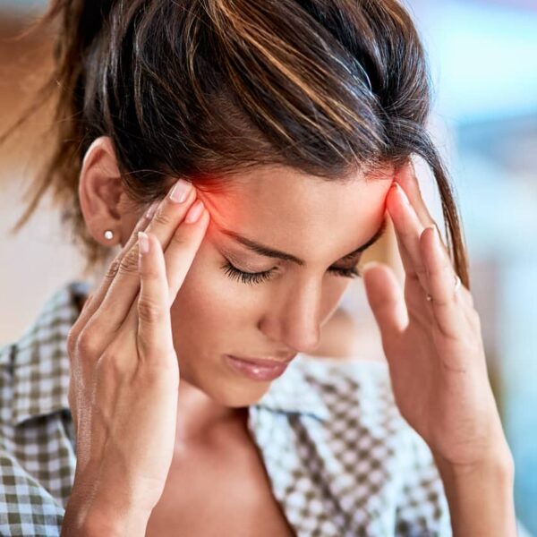 Woman holding her head with headache from comedown