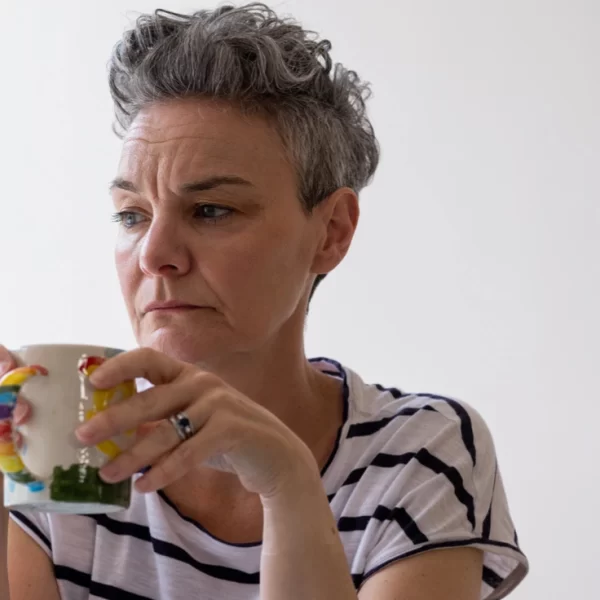 An image of a middle-aged woman with short grey hair appearing worried, thinking about the early signs of alcohol-related dementia