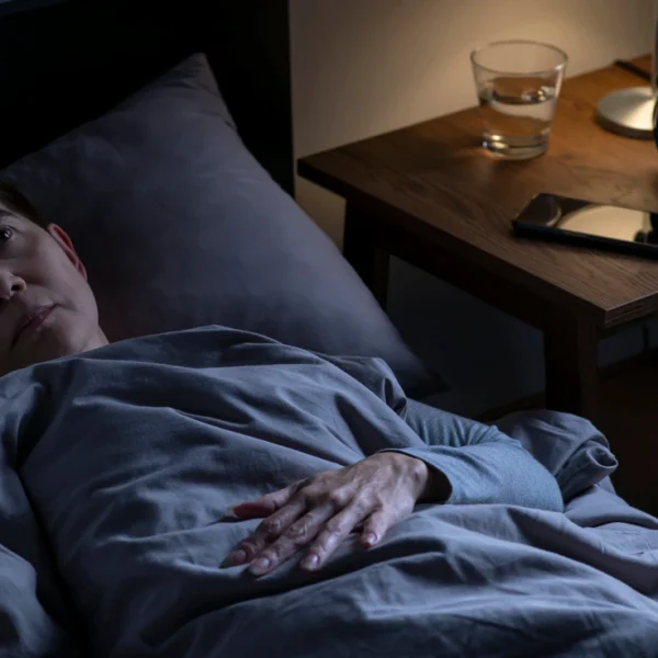 can weed cause insomnia? An image of an individual in bed whilst wide awake, indicating that they are having trouble getting to sleep.