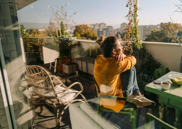 How can addiction be prevented? An image of a woman enjoying the sun on a balcony